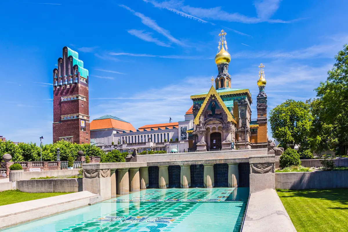 Die russische Kapelle und der Fünffinger-Turm aus Darmstadt an einem sonnigen Tag mit blauem Himmel.